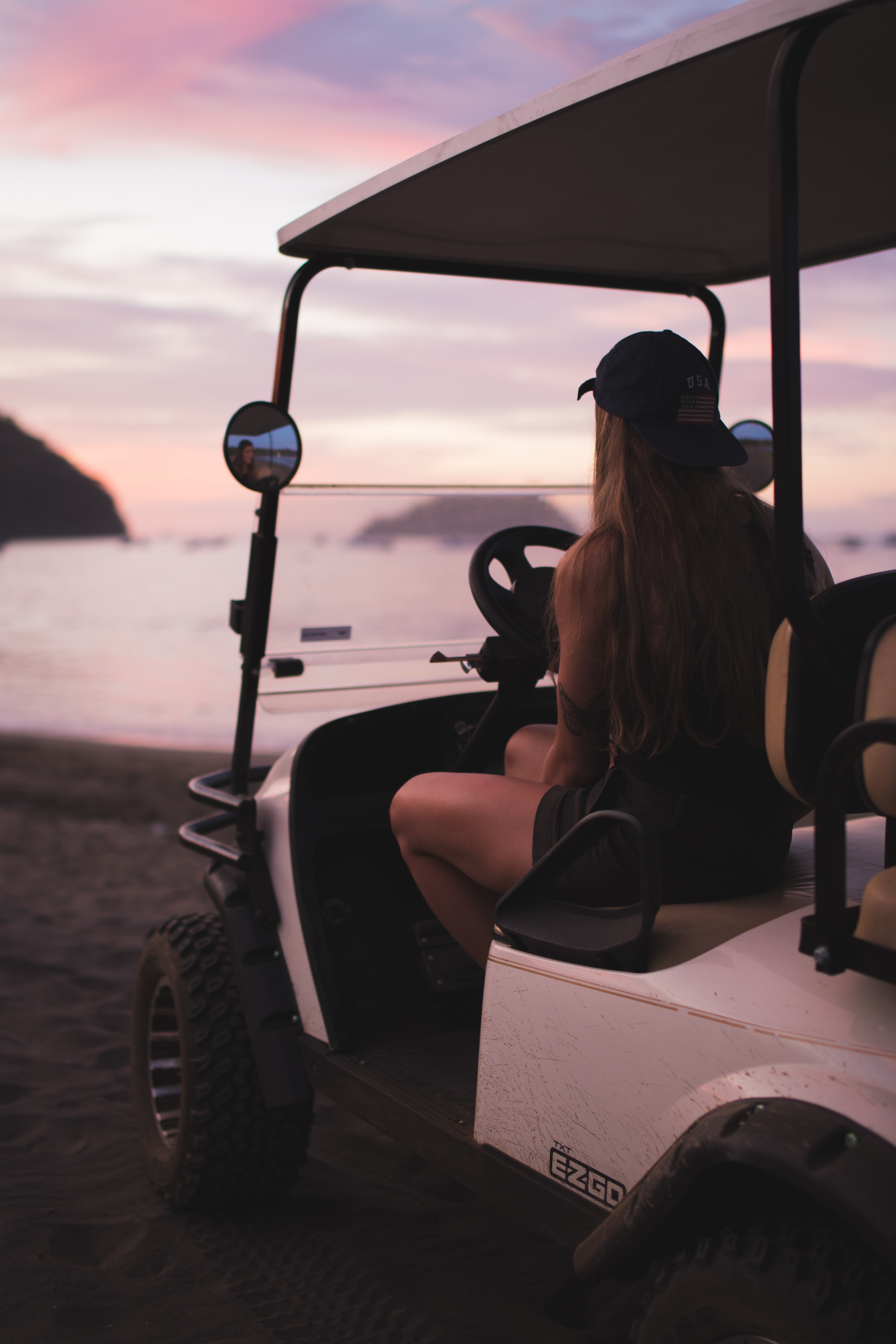 woman sitting in golf cart watching sunset